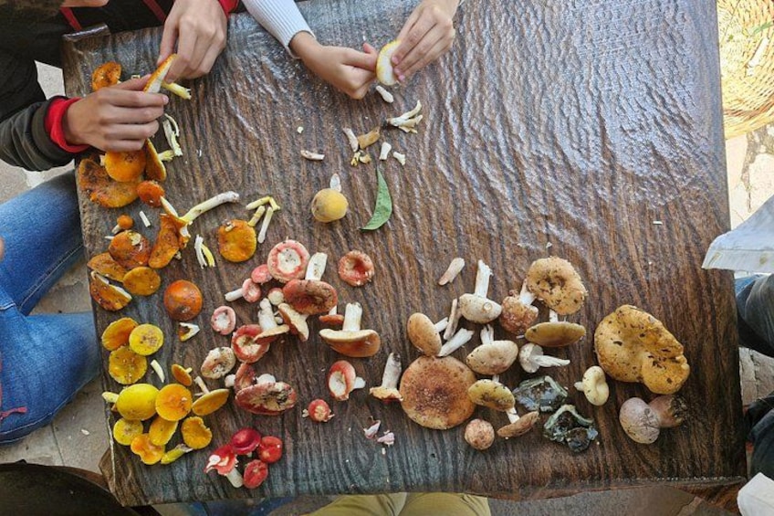 Des personnes sont en train de peler et de trier différents fruits et légumes sur une table en bois. 5
