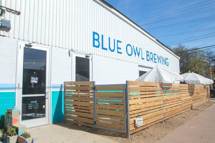 A building with a sign reading 'BLUE OWL BREWING.' 5