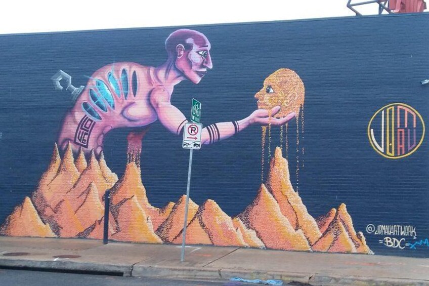 A mural with a human figure, a traffic sign, and a logo. 4