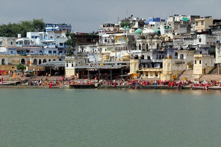 A densely packed urban area with historic buildings, a river, and a crowd of people. 2