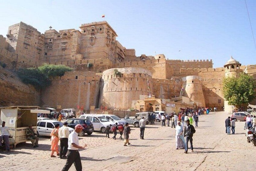 A historic fort with tourists and vehicles. 3