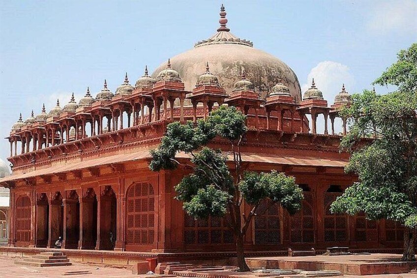 A large, ornate building with a domed roof and multiple smaller domes, surrounded by a garden with trees. 5
