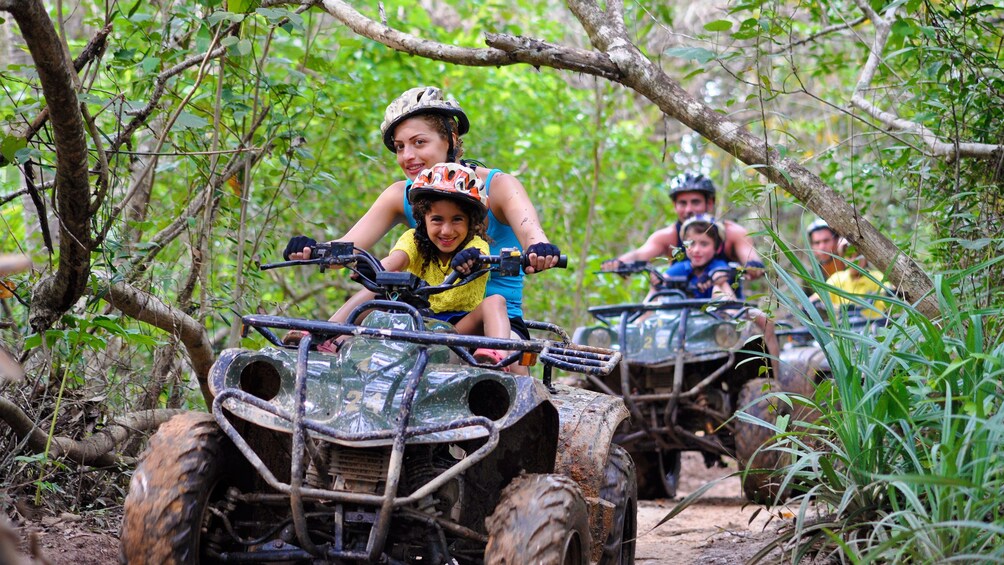 Mother and daughter riding through a muddy path in Phuket. 