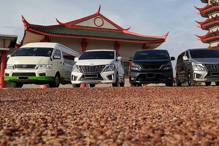 A row of vehicles parked in front of a traditional building with a red roof. 4