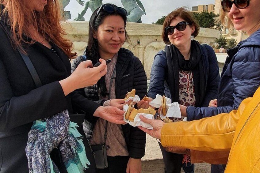 Eating Imqaret at the Triton Fountain. 3