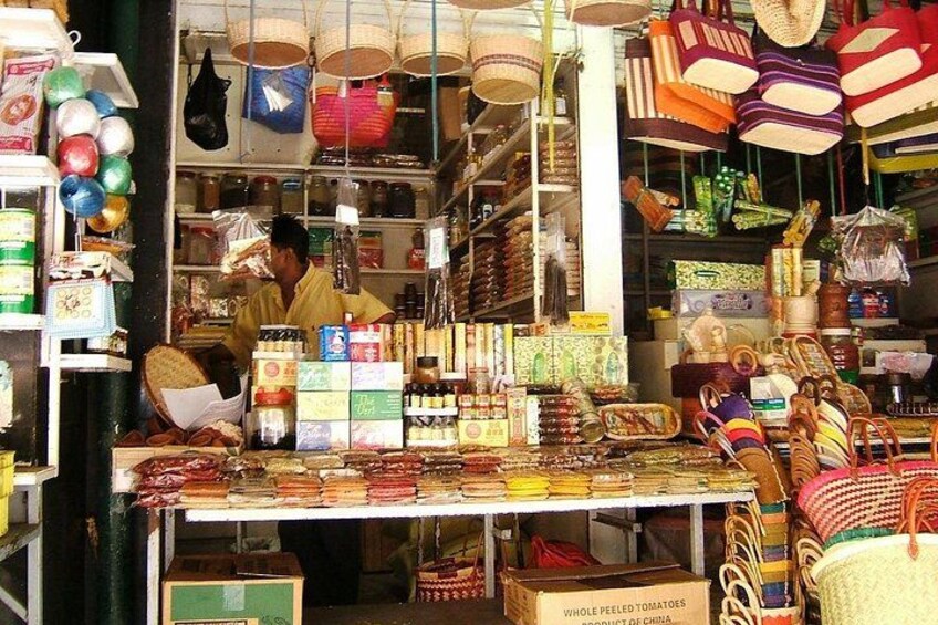 Un puesto de mercado con diversos artículos, incluyendo cestas, bolsas y productos envasados. 2