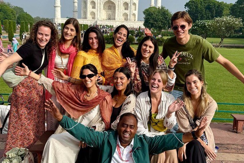 Un groupe de personnes posant devant le Taj Mahal. 2
