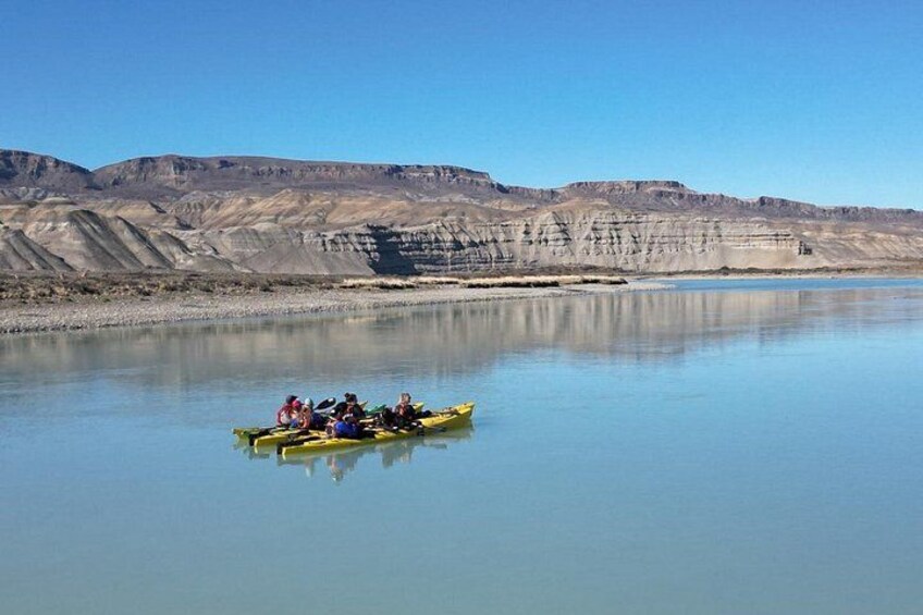 A calm river with a group of people in a yellow canoe. 3