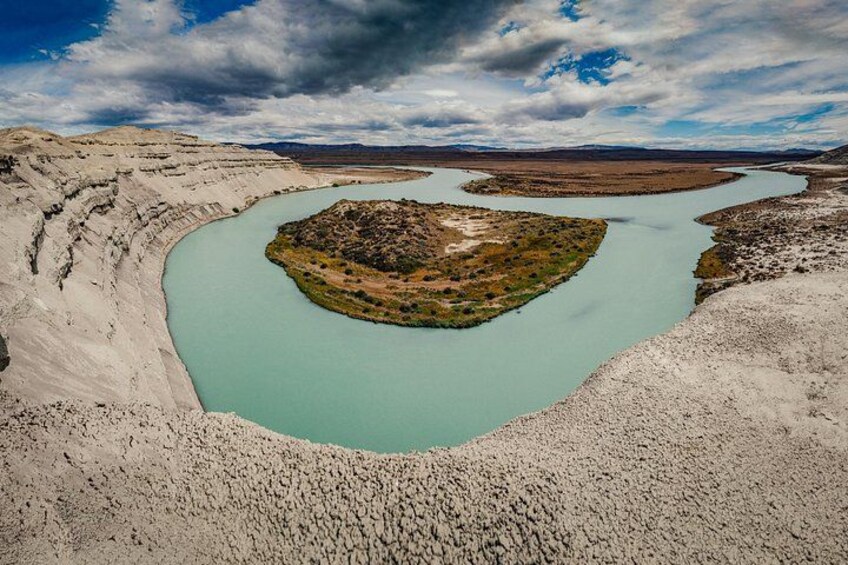A river winding through a barren landscape with a small island in the center. 2