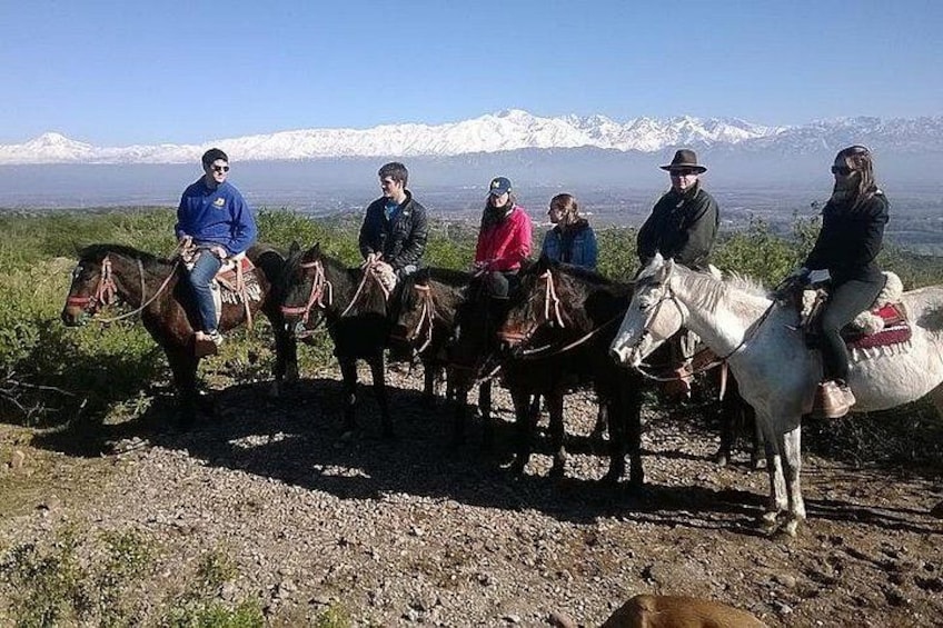 A group of people on horseback with a mountainous landscape in the background. 4