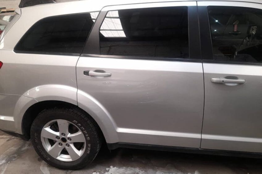 Un SUV plateado estacionado sobre una superficie de concreto. 1