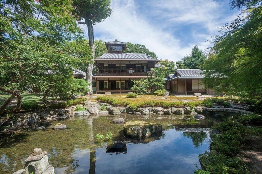 A traditional Japanese building with a pond and koi fish. 1