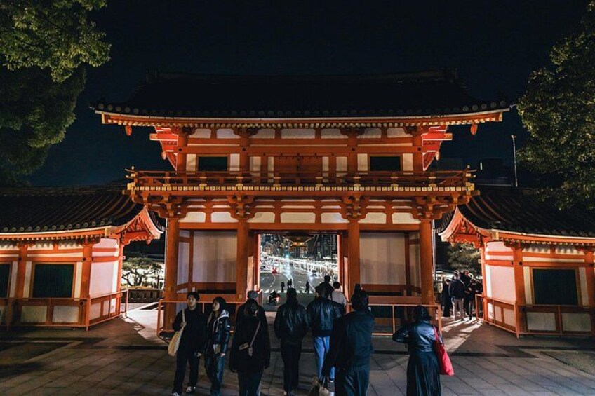 En traditionel japansk torii-port om natten med mennesker, der går forbi. 3