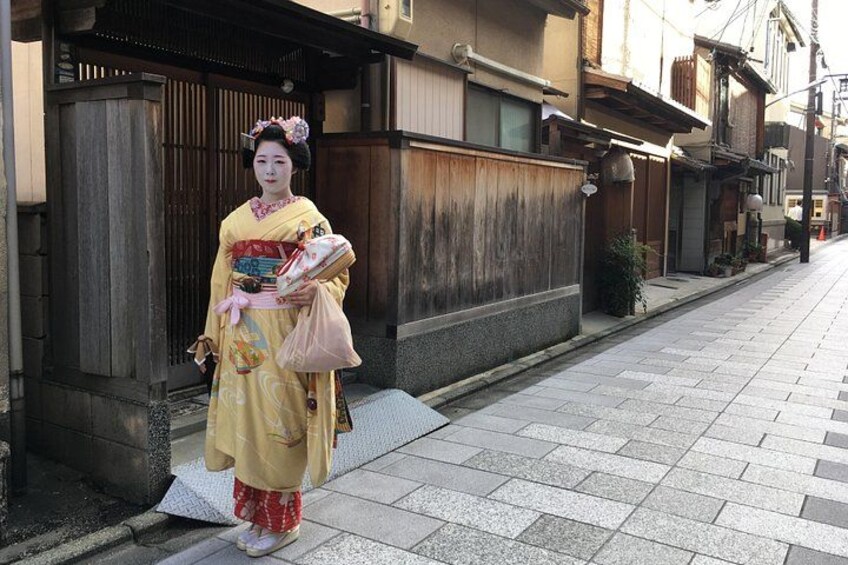 En person i traditionelt japansk tøj står på et fortov. 2