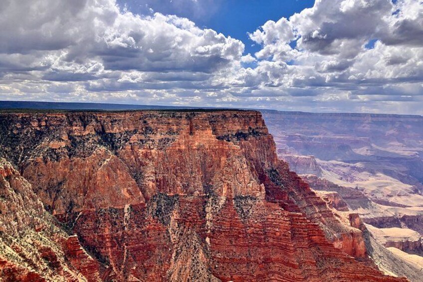 Un cañón con formaciones rocosas estratificadas y un cielo nublado. 5