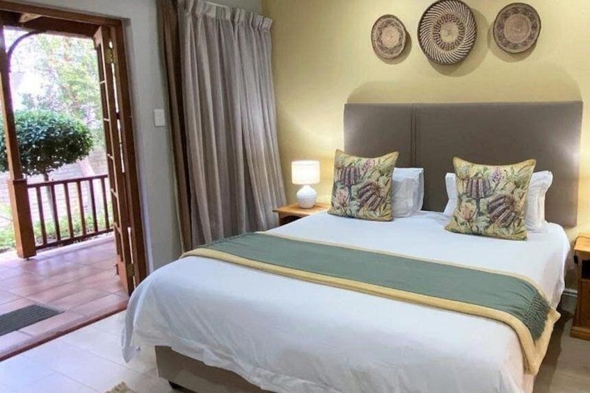 A bedroom with a bed, curtains, and wall decor. 5