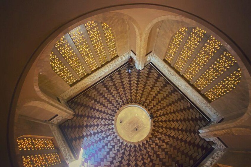A spiral staircase with patterned floor tiles and decorative lighting. 3