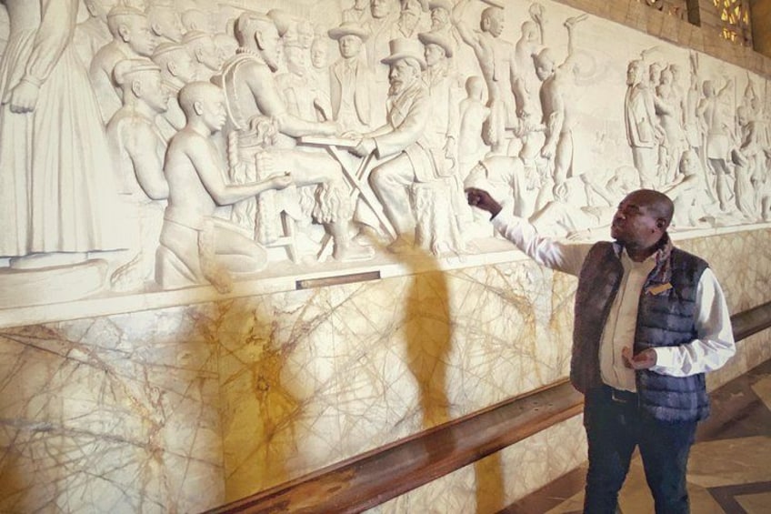 A marble wall with a relief sculpture of a historical scene. 5