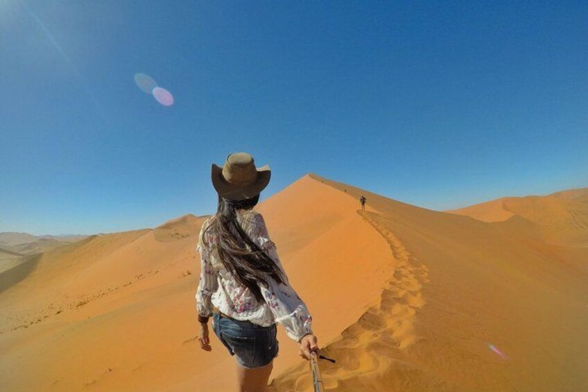 A person hiking in a desert with sand dunes. 2