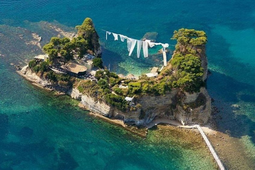 An aerial view of a small island with a beach, cliffs, and a flag. 2