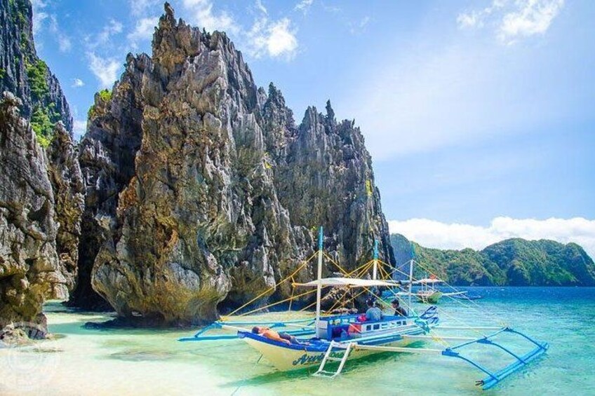 A boat anchored near a rocky coastline with clear turquoise water. 5