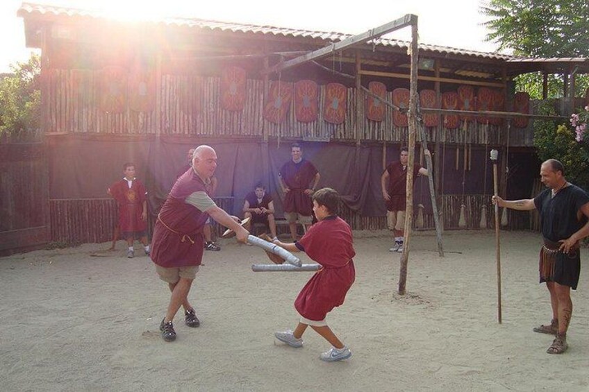 Iemand speelt honkbal met een knuppel en bal, een andere persoon houdt een knuppel vast, en een kind draagt een rode outfit. 2