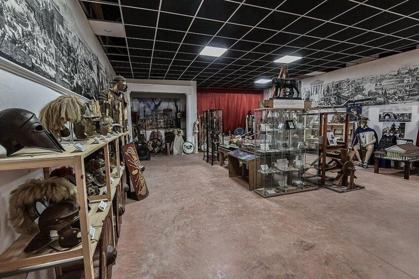 Un museo con artefactos históricos, como cascos y armas, exhibidos en estanterías y vitrinas. 4
