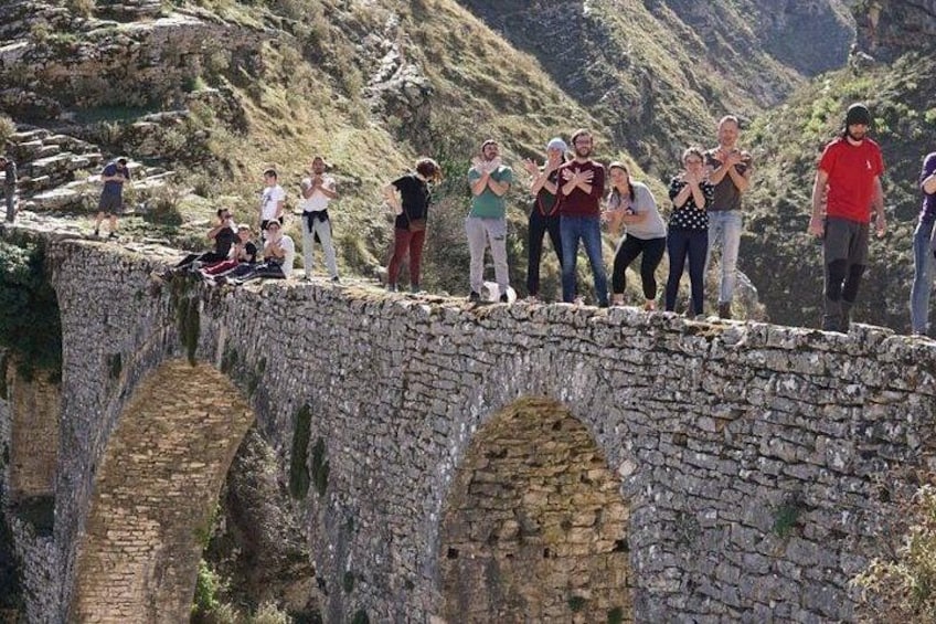 A stone bridge with people standing on it. 2