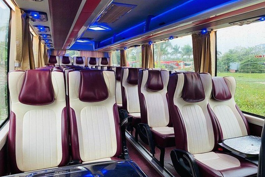 A train interior with rows of seats, overhead luggage compartments, and windows. 5