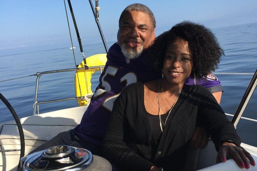 Two people on a boat with a calm sea in the background. 3