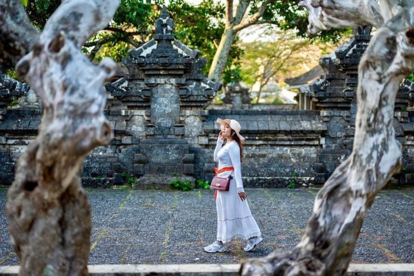 A person walking in front of a stone temple with intricate carvings. 2