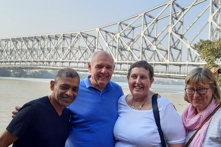 Un groupe de personnes se tient devant un grand pont à structure en treillis. 1