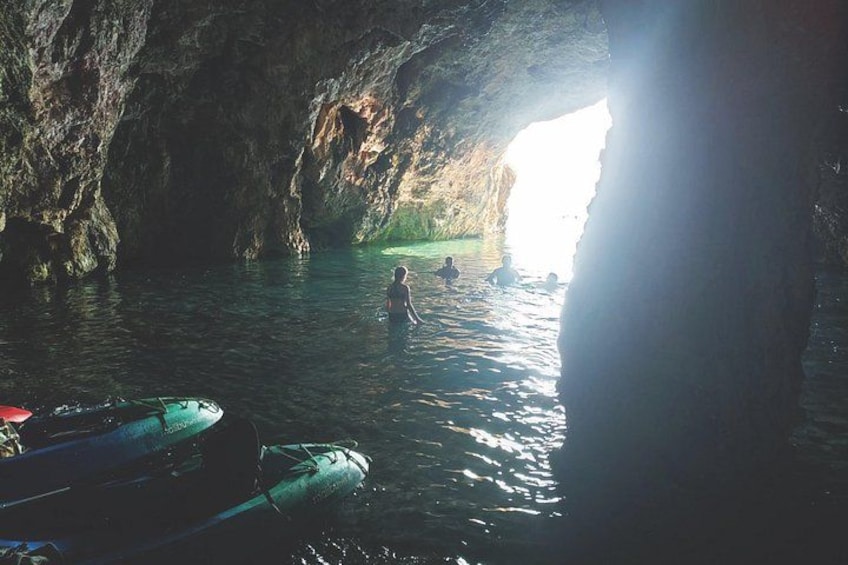 A cave with water, kayaks, and people. 2