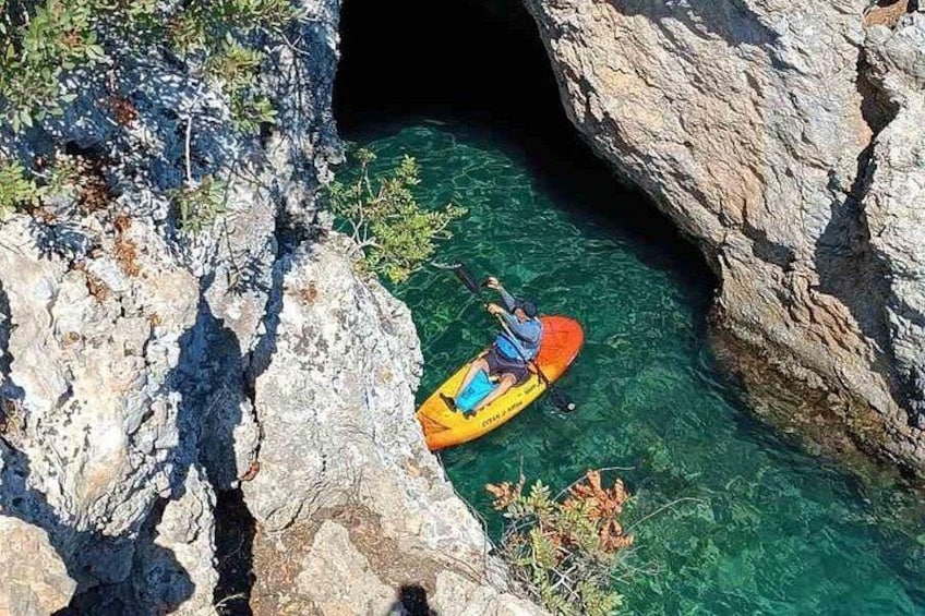 A person kayaking in a narrow canyon with clear water. 4
