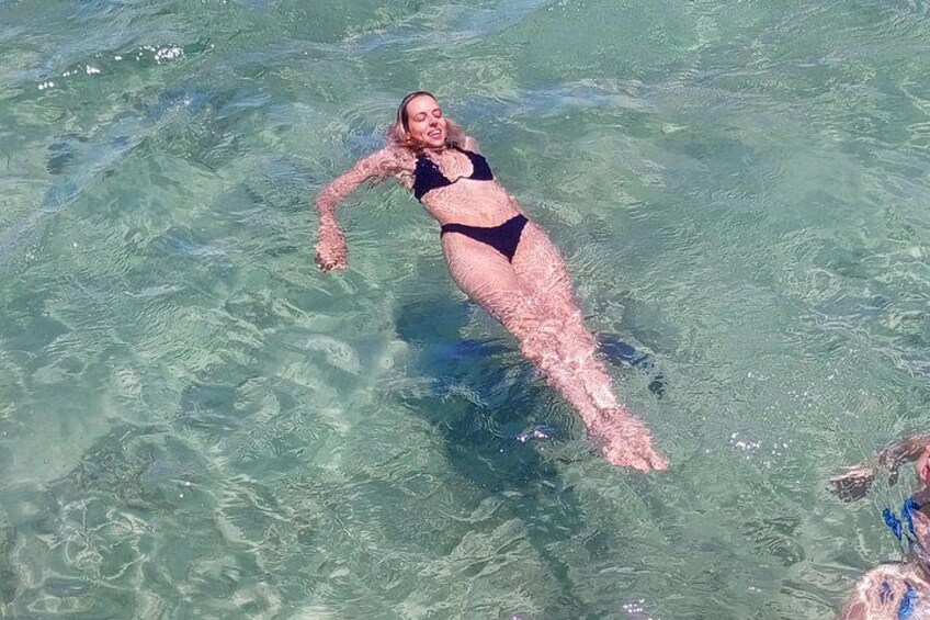 A person floating on water wearing a swimsuit. 5