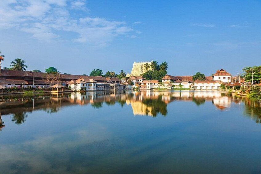 Un lago tranquilo con reflejos de edificios y una estructura destacada al fondo. 1