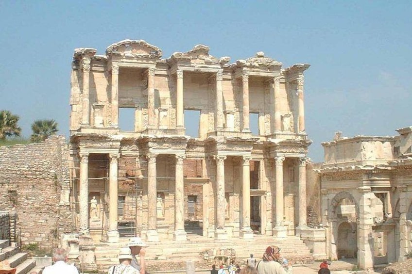 Ancient ruins with columns and arches, surrounded by tourists. 5