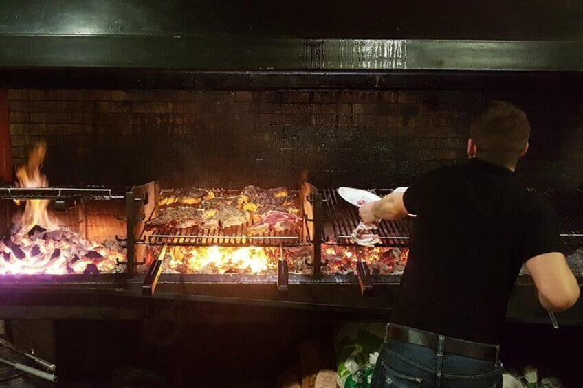A person grilling meat on a large outdoor grill. 1