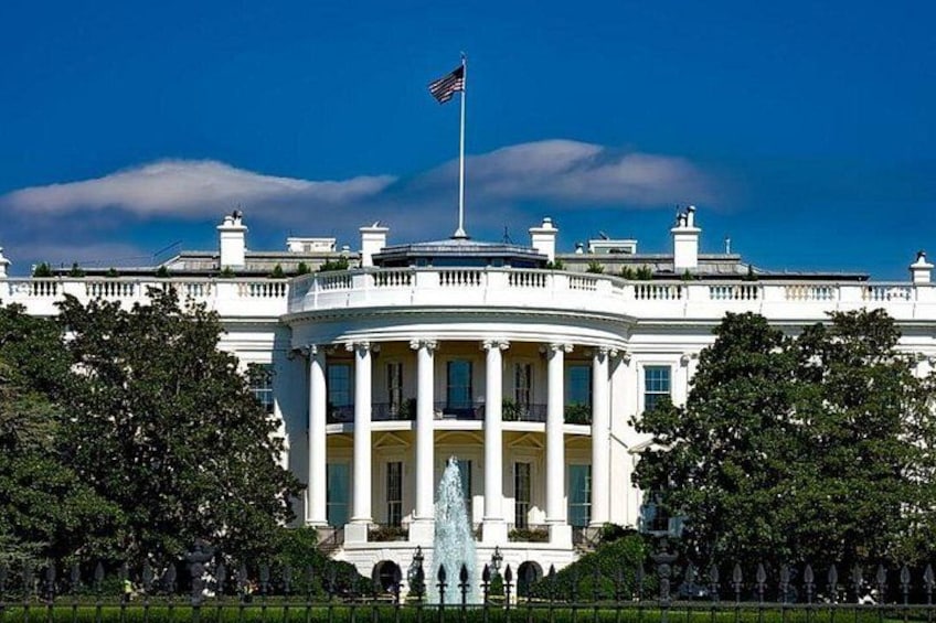La Casa Blanca con una bandera, columnas y una fuente. 4
