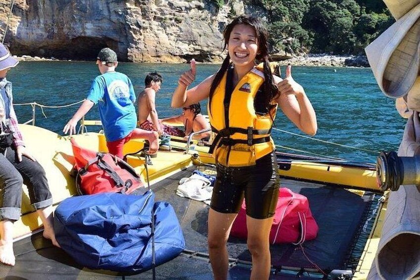 Una persona en un bote, con chaleco salvavidas, y otras personas y equipo cerca. 4