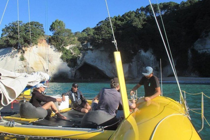 Un grupo de personas en un barco amarillo cerca de una costa rocosa con acantilados. 2