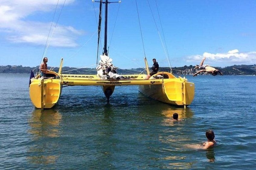 Un bote amarillo con dos personas y otra nadando en el agua. 5