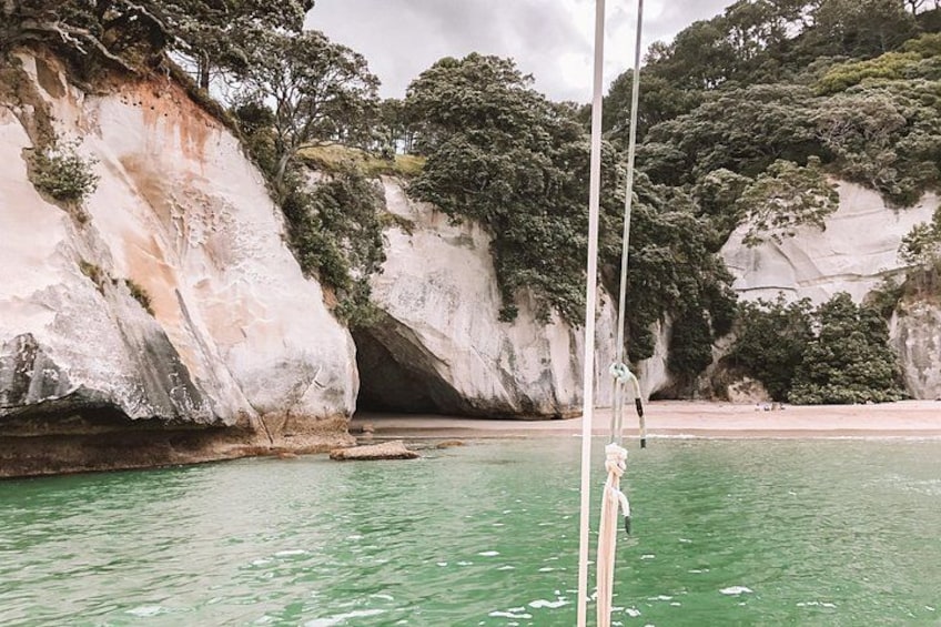 A coastal landscape with cliffs, a beach, and a body of water. 2