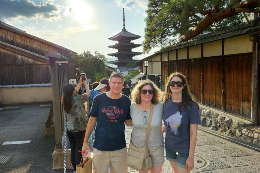A traditional Japanese pagoda, tourists, and a wooden fence. 4