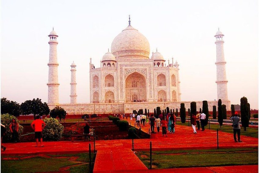 The Taj Mahal with its four minarets, a large central dome, and a red carpet leading to the entrance. 1