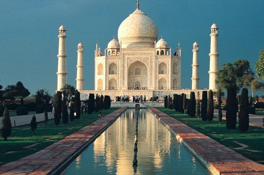Taj Mahal spejlet i vandet, omgivet af en have med stier. 3
