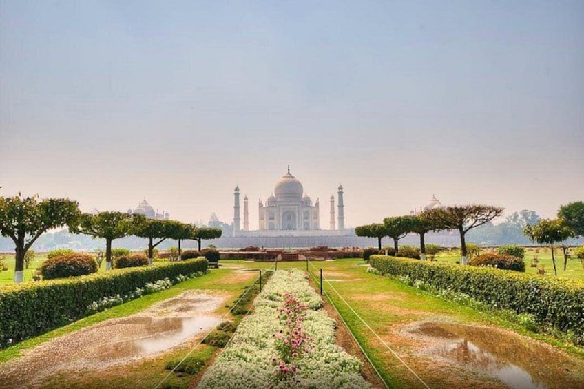 The Taj Mahal with a symmetrical garden layout, including pathways and trimmed hedges. 1