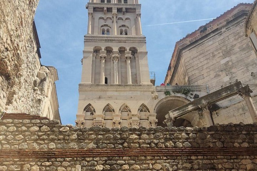 Un edificio histórico con una torre alta, muros de piedra y ventanas en arco. 3