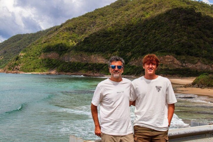 Two people standing by a beach with a mountainous backdrop. 3