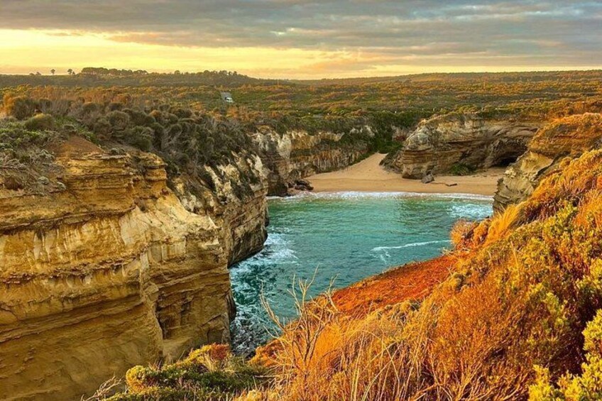 A coastal landscape with cliffs, a beach, and a river. 2